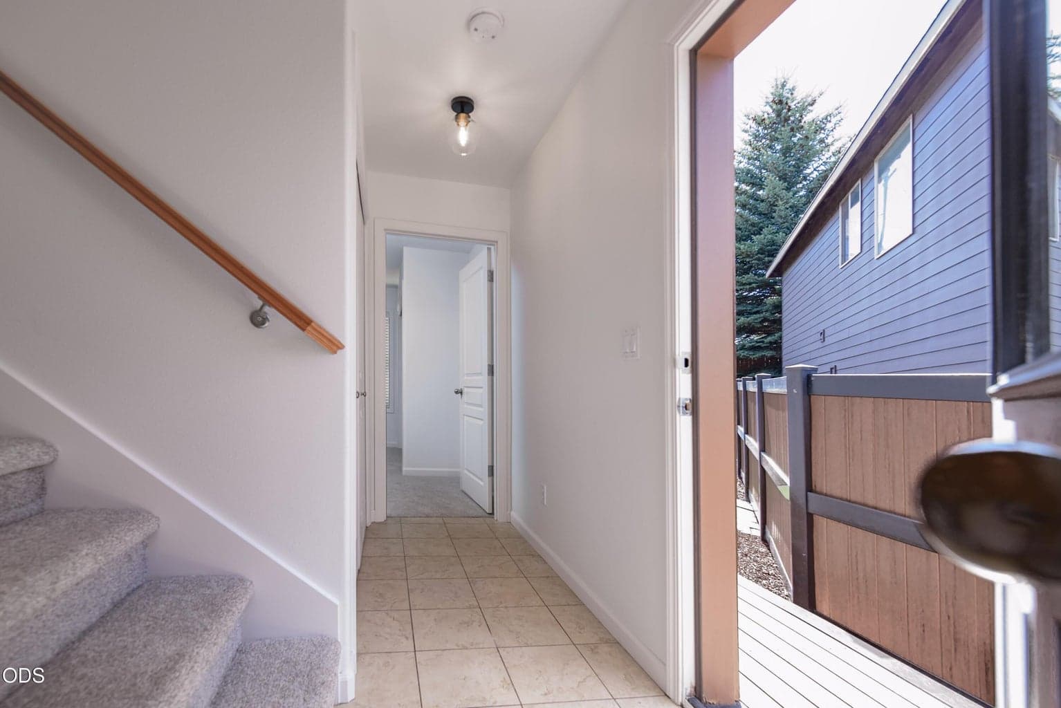 Door out to the fenced yard with a deck and patio