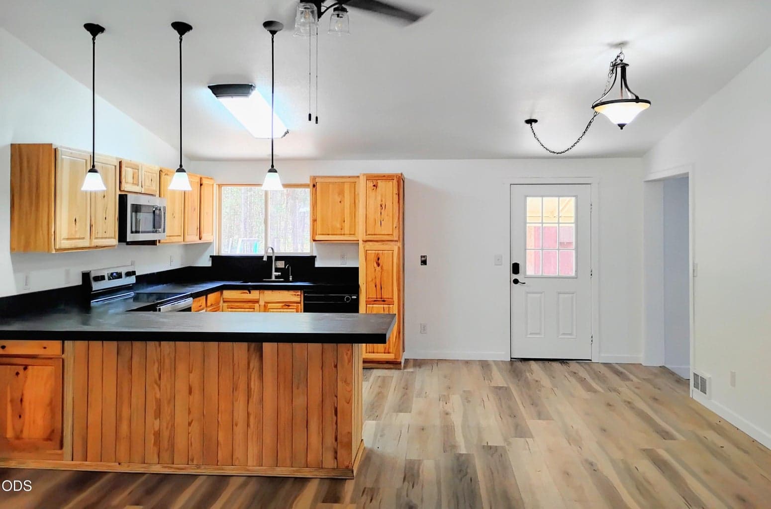 Bright kitchen and rear entry area featuring updated flooring, modern lighting, and convenient access to the backyard or utility area.