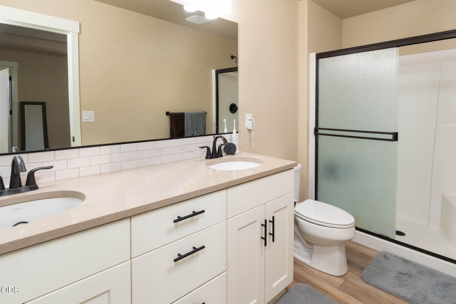 Spacious en-suite features dual vanity, solid-surface counters, and large shower complete with glass doors.
