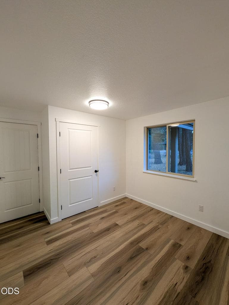 Secondary bedroom with updated flooring, neutral finishes, and closet space.