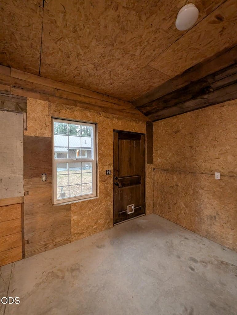 Shop interior with wood walls, window for natural light, and open floor space for flexible use.