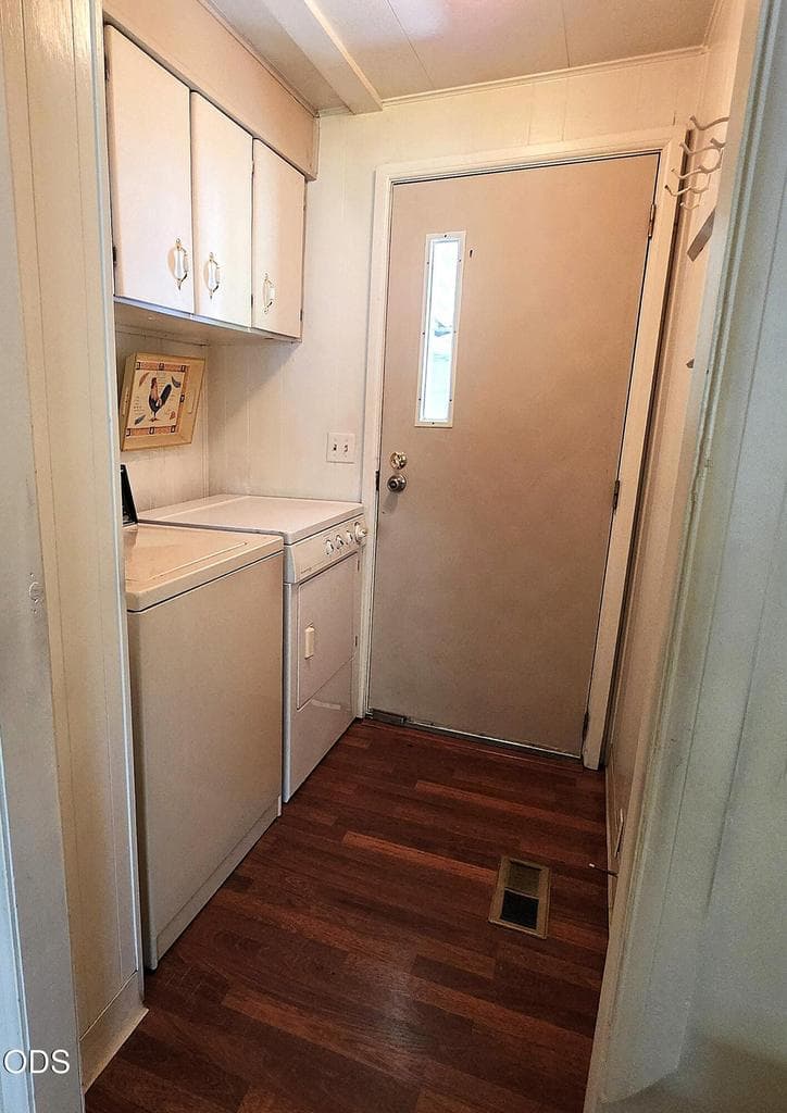 Separate laundry room with overhead cabinets