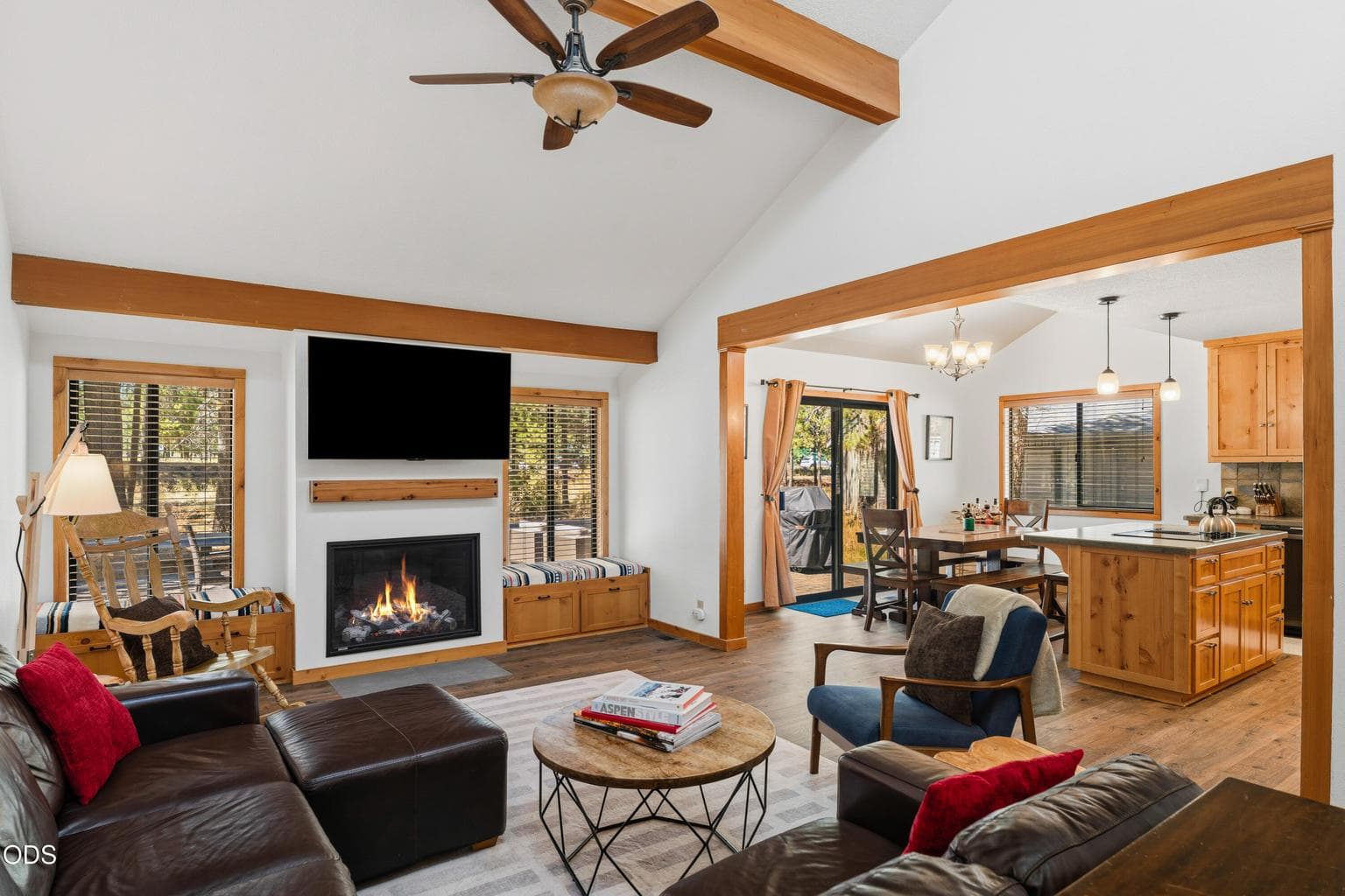 Vaulted ceilings, a cozy gas fireplace with built-in window seating, and abundant natural light create a warm and inviting great room.