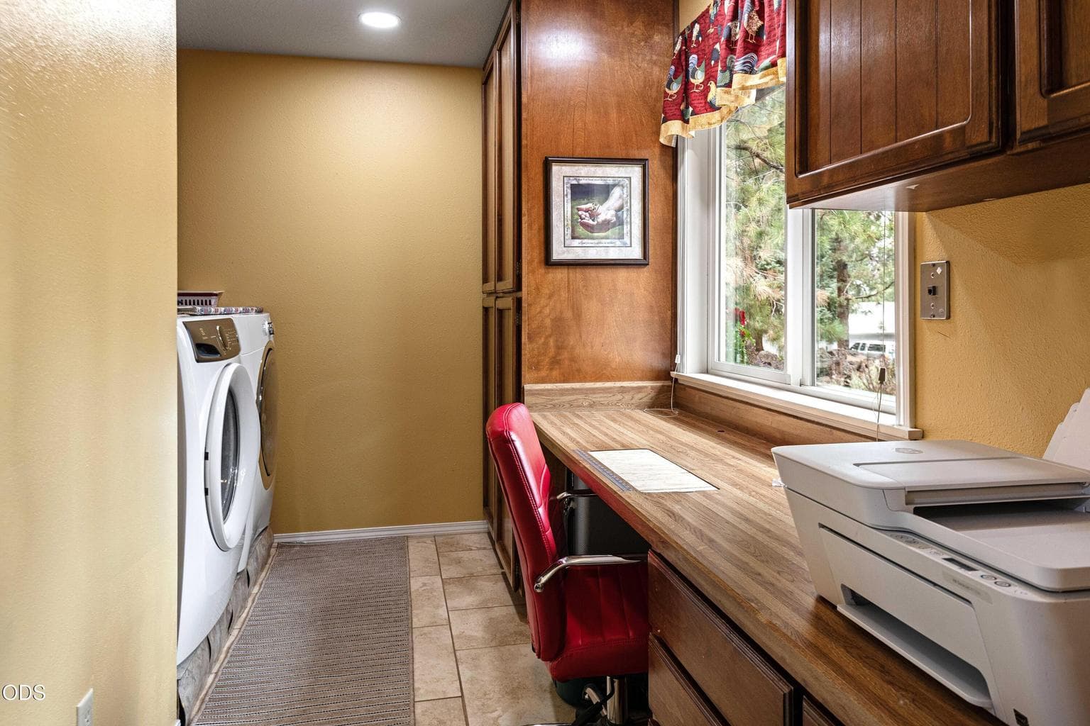 Laundry room has long, built-in counter and cabinetry for storage