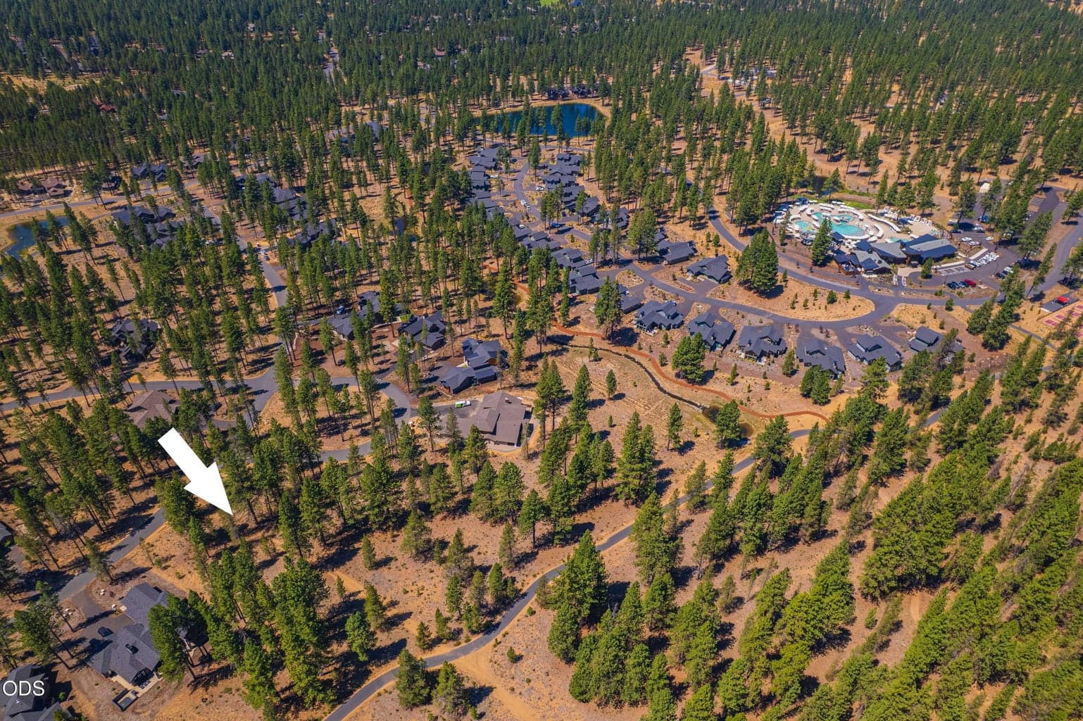 A broader aerial places 56343 Mirror Rock Loop, Lot 333 within Caldera Springs, pairing a peaceful wooded homesite with convenient access to the community amenities.