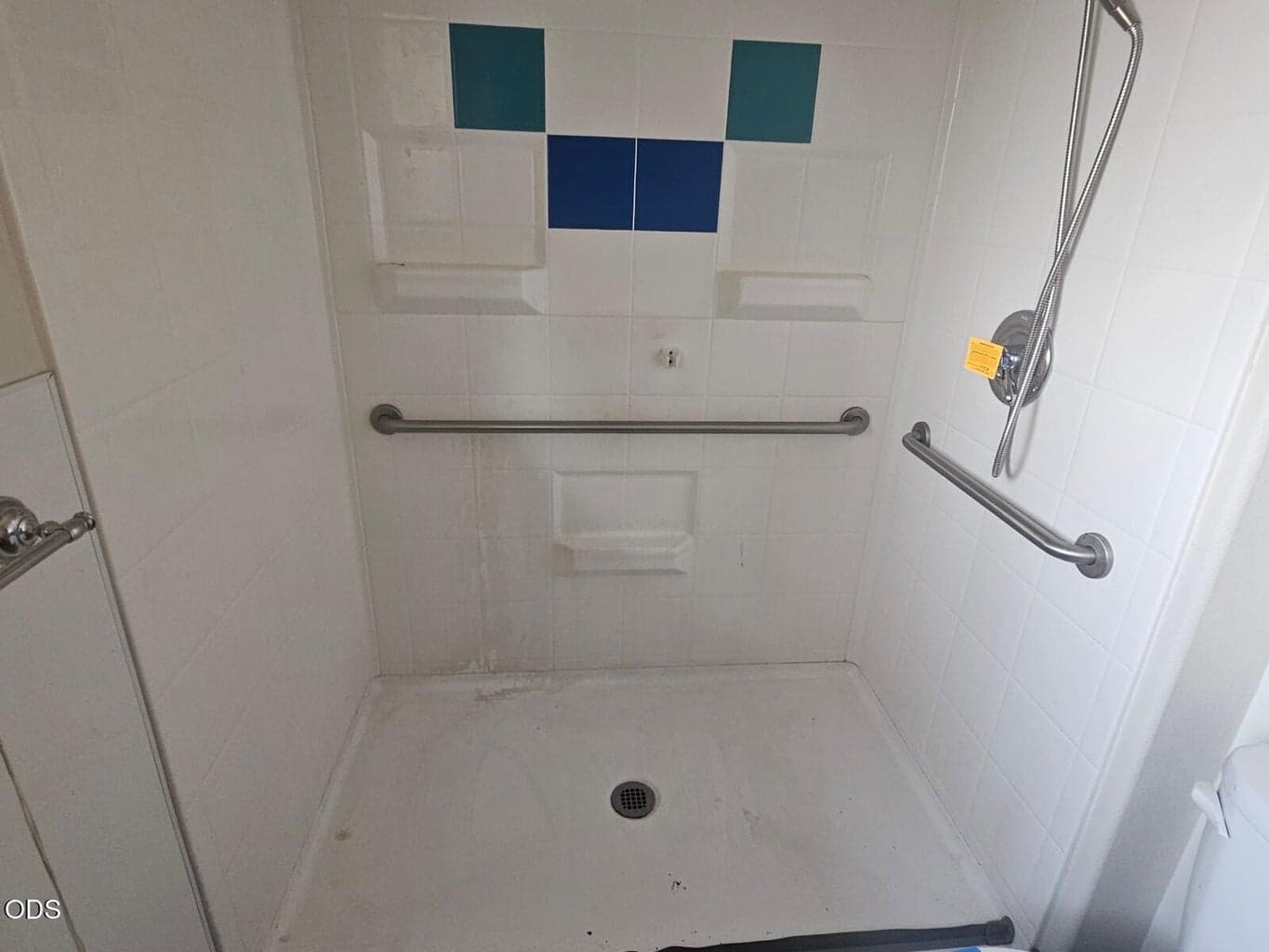Almost curb-less shower with chair height safety rails