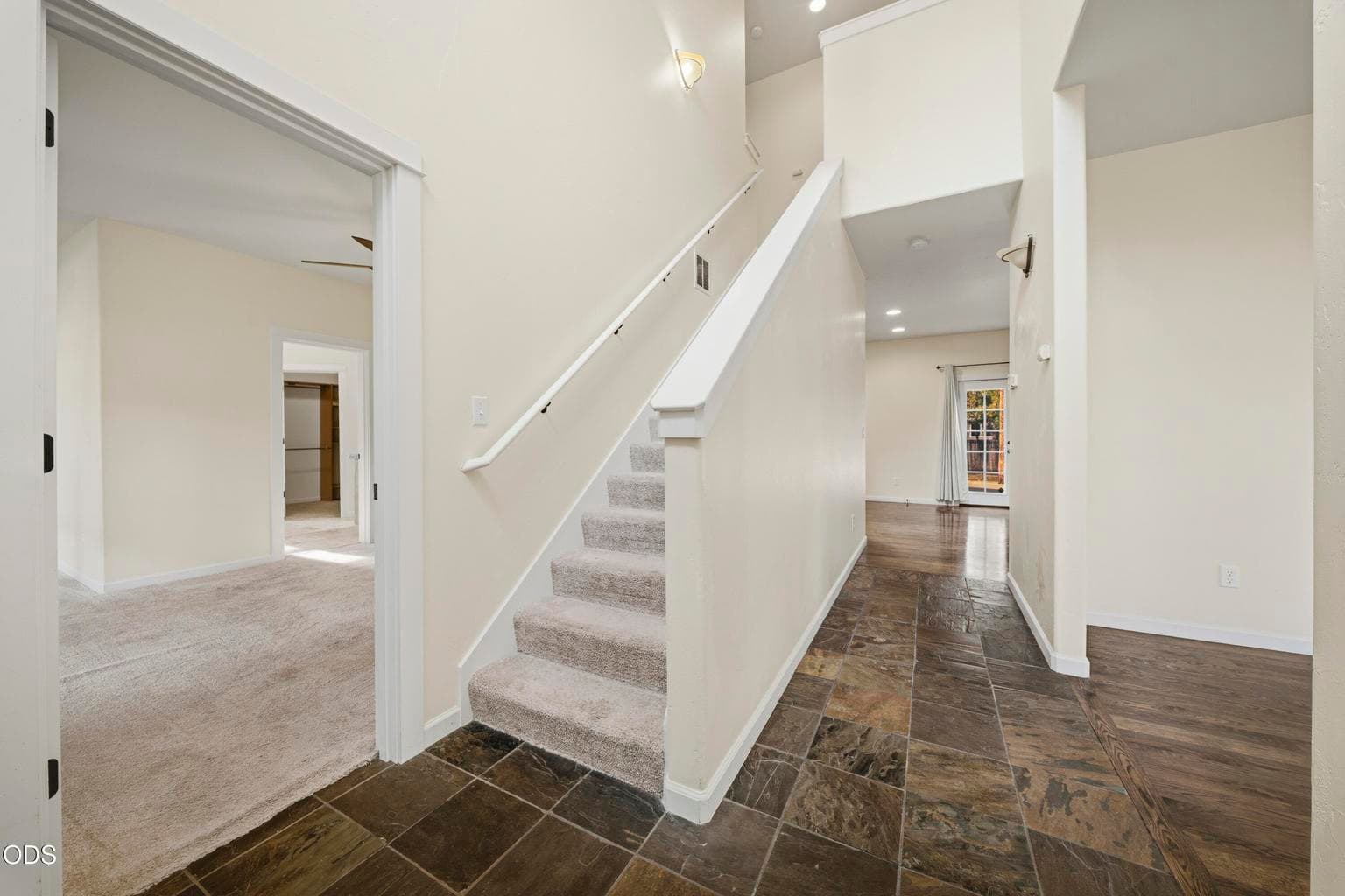 The two story entry is lit with an overhead window and beautiful slate on the floor
