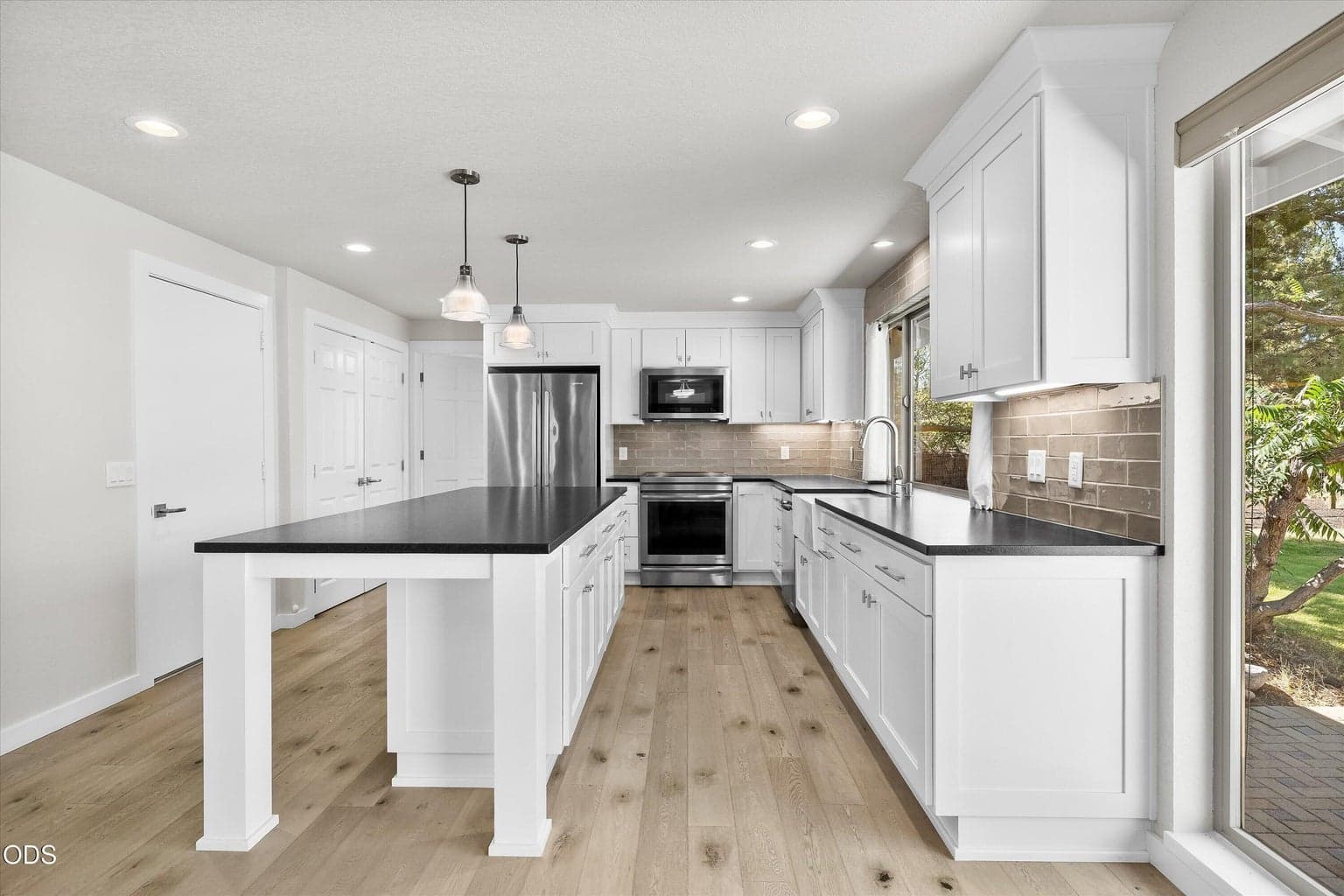 The upgraded kitchen has hard surfaces countertops, a farmers sink and Jennair appliances.
