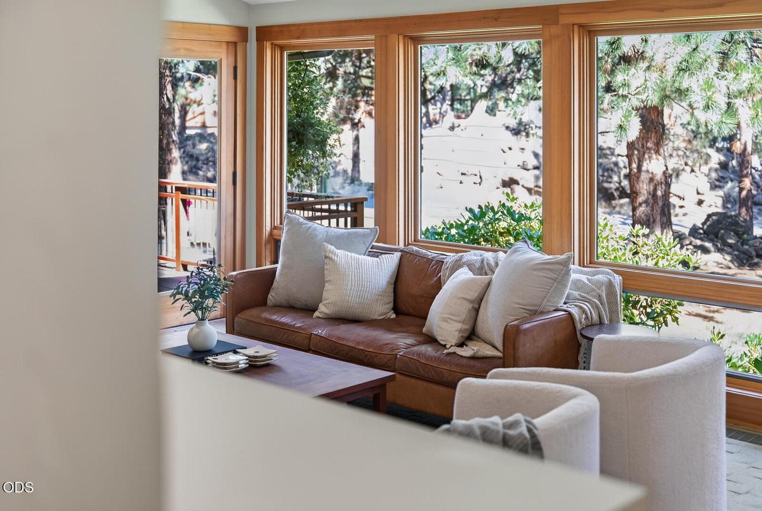 Light and bright, allowing the outside in. One of three decks is just beyond the living room couch and to the left.