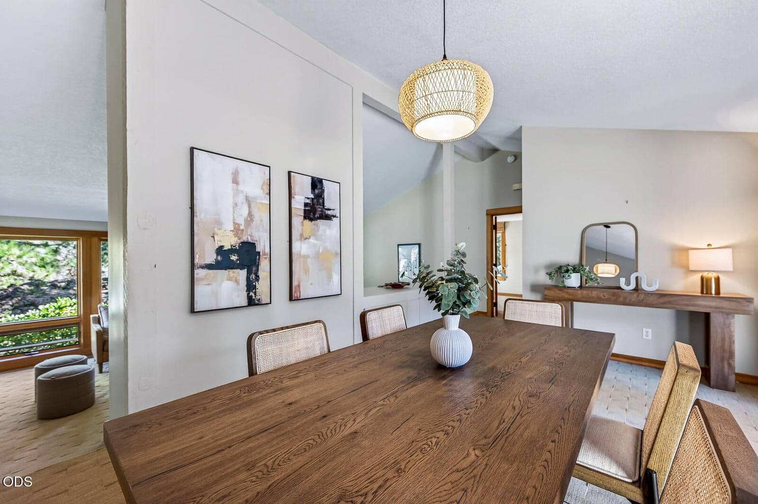 Living room with open area and tall ceilings beyond the wall