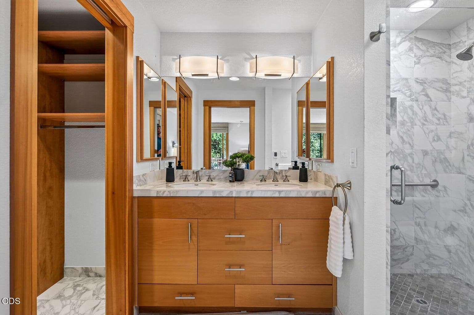 Primary bathroom with a double sink vanity. The walk in closet is to the left