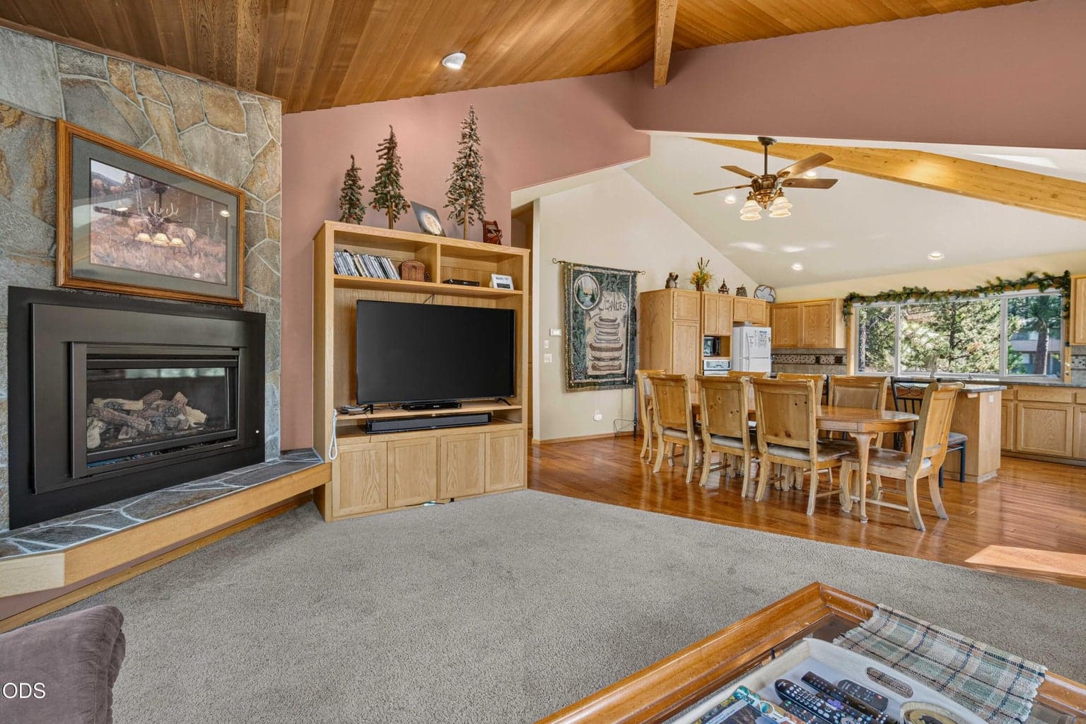 Gather around the stone-surround fireplace while staying connected to the kitchen and dining spaces beyond.