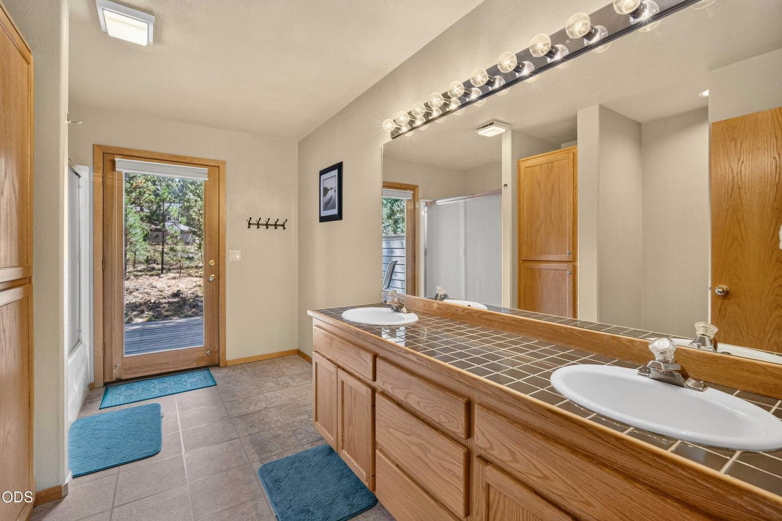 A full guest bath serves the two additional downstairs bedrooms and includes direct access to the back of the home, adding extra convenience for family, guests and outdoor living.