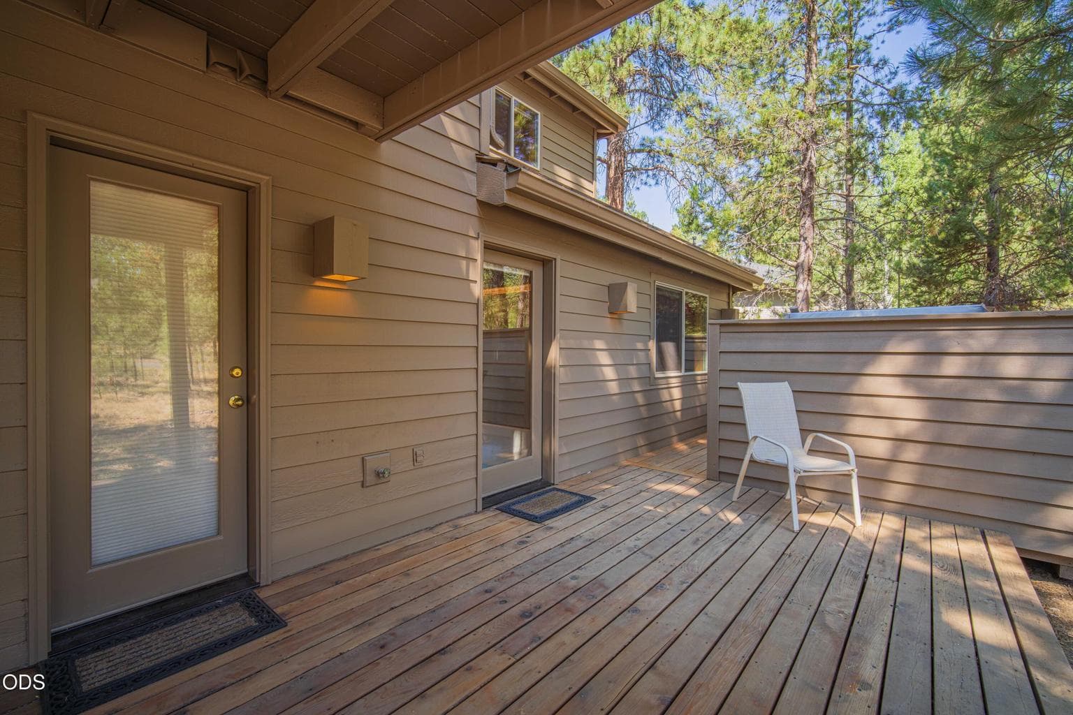 Covered lower-level outdoor space offers another way to enjoy the wooded setting in sun or shade.
