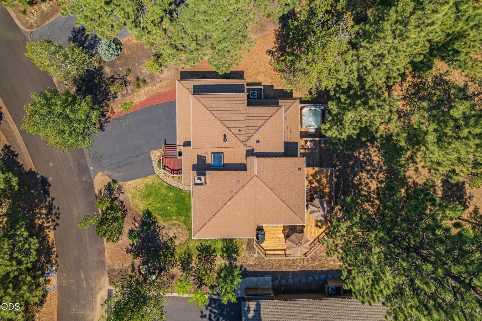 An aerial view shows how the home and outdoor living spaces are tucked naturally into the surrounding pines.