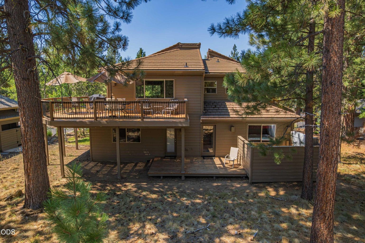 The rear of the home reveals multiple outdoor spaces designed for gathering, relaxing and taking in the setting.