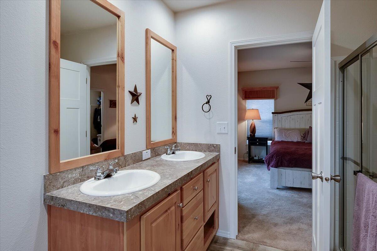 Primary bathroom vanity with two sinks and fiberglass shower