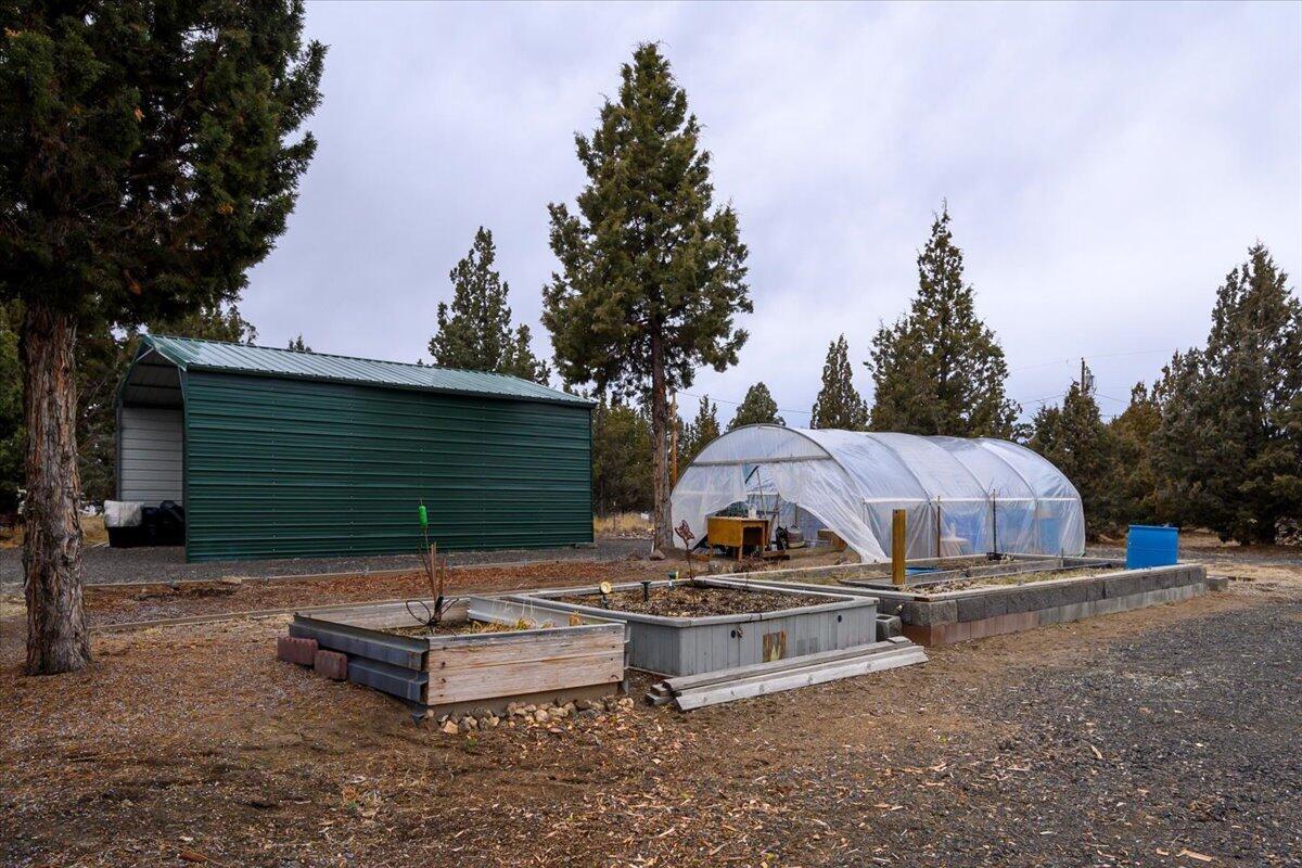 Large greenhouse, garden beds and carport