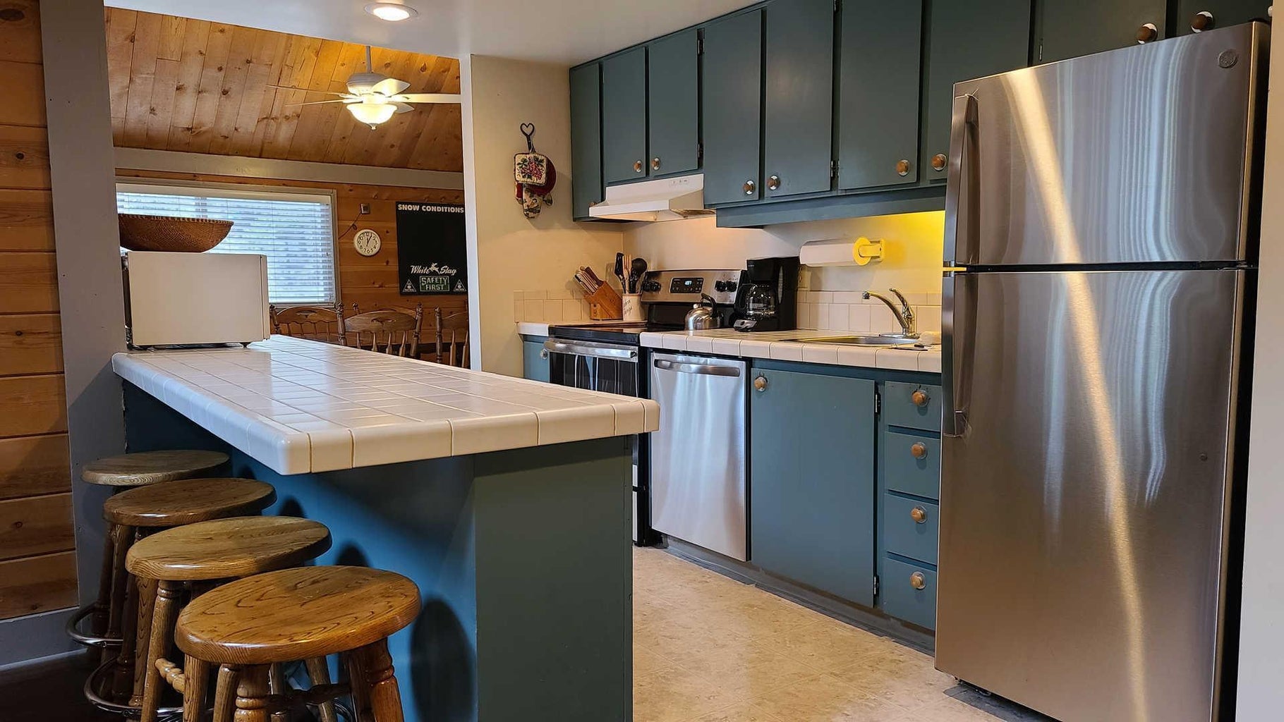 Eye-catching blue cabinets pop against classic white tile countertops and stainless Steele appliances.