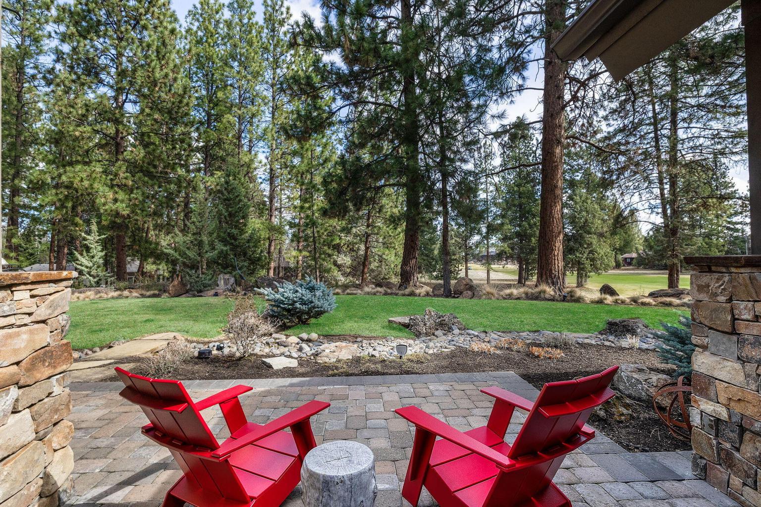Additional outdoor seating area with fire pit, set along the landscaped edge of the yard with views to the golf course.