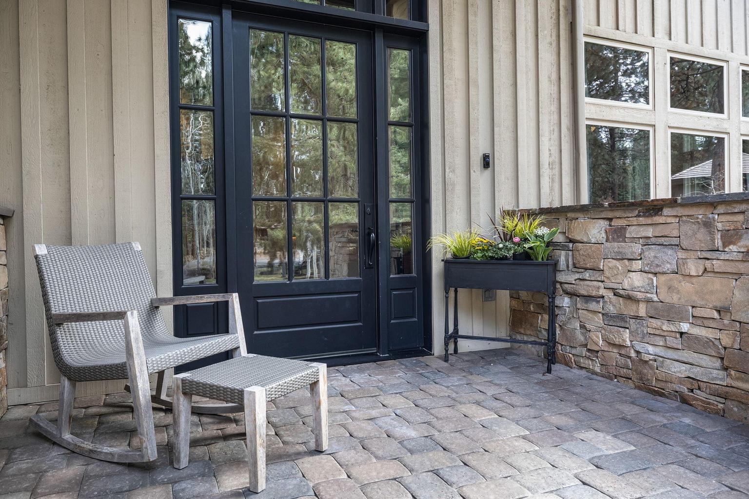 Private front patio with stone detailing, offering a quiet, welcoming outdoor setting.