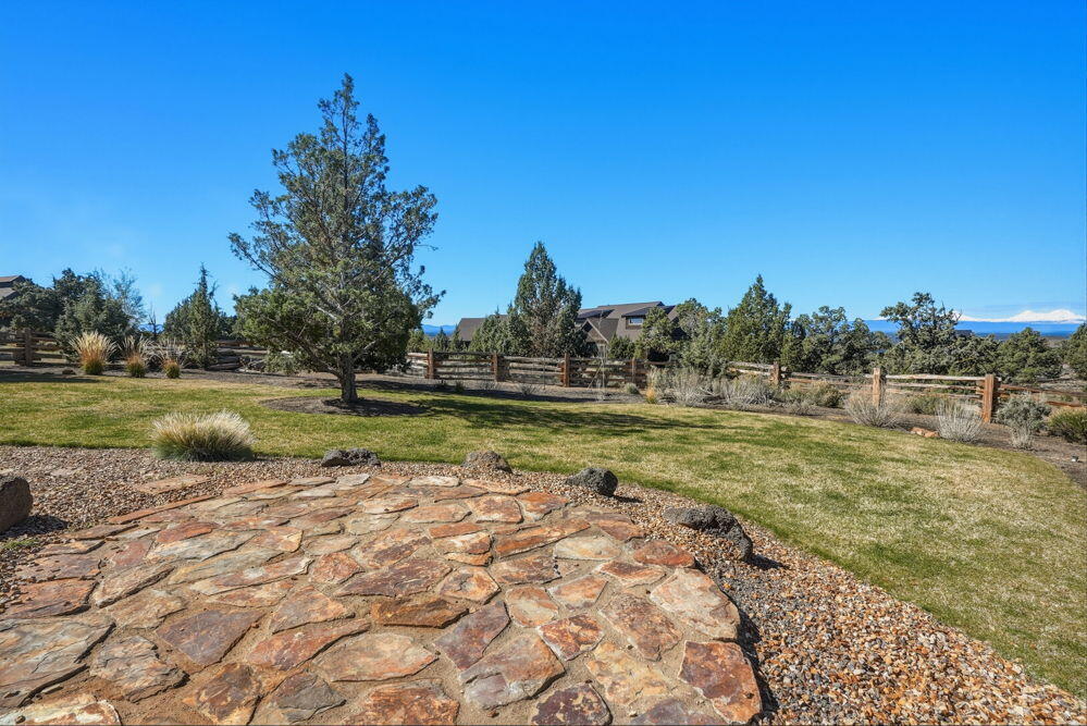 Fenced yard with grass and stone area ready for your firepit