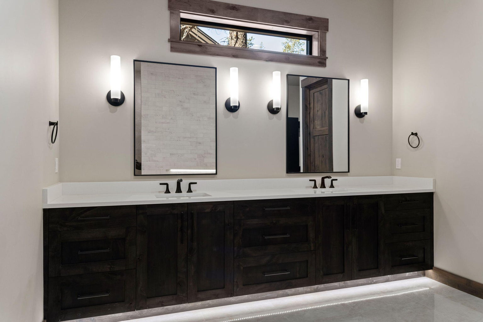 Main level Primary ensuite bathroom boasts heated tile floors and dual vanity and solid surfaces throughout