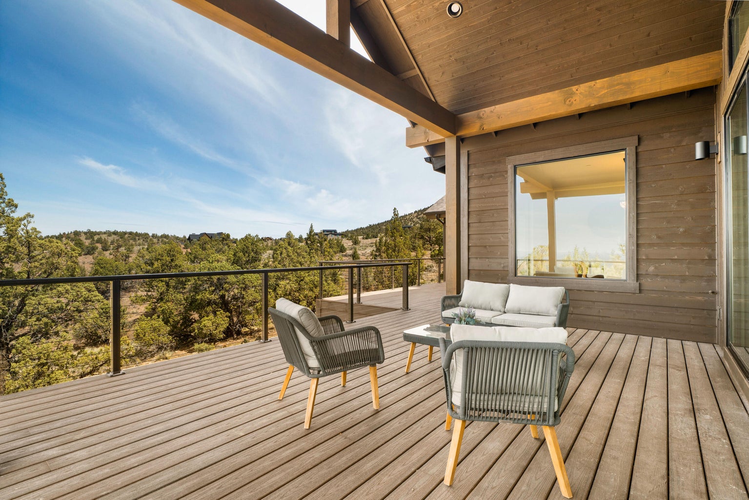 Peaceful nature views in all directions from the deck that connects the great room, dining room, and primary suite