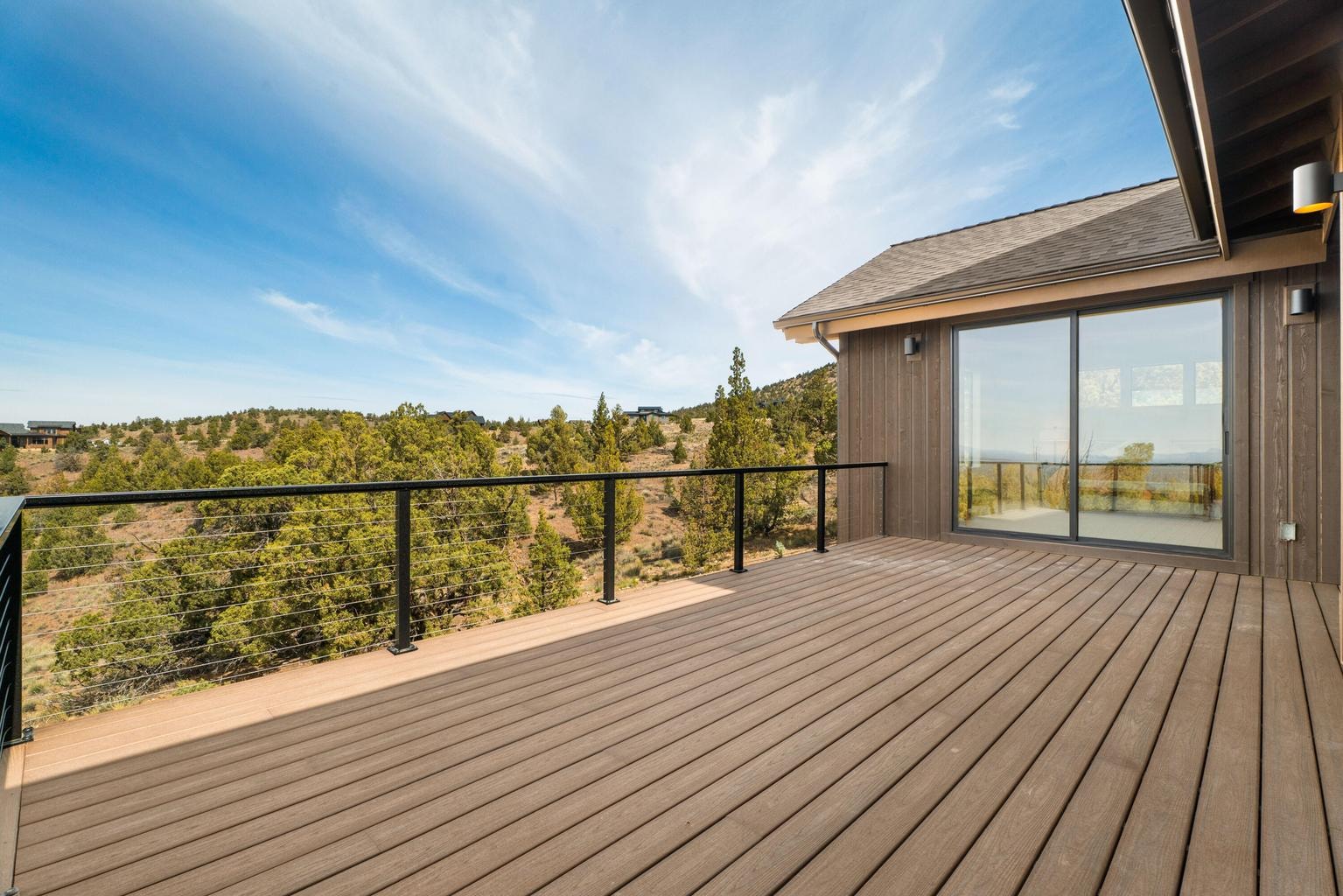 Oversized doors of full glass lead to the primary suite deck, that does connect to the rest of the back deck but is set back for privacy