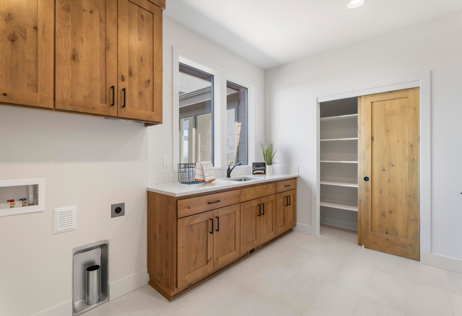 Laundry room with utility sink, storage, and linen closet