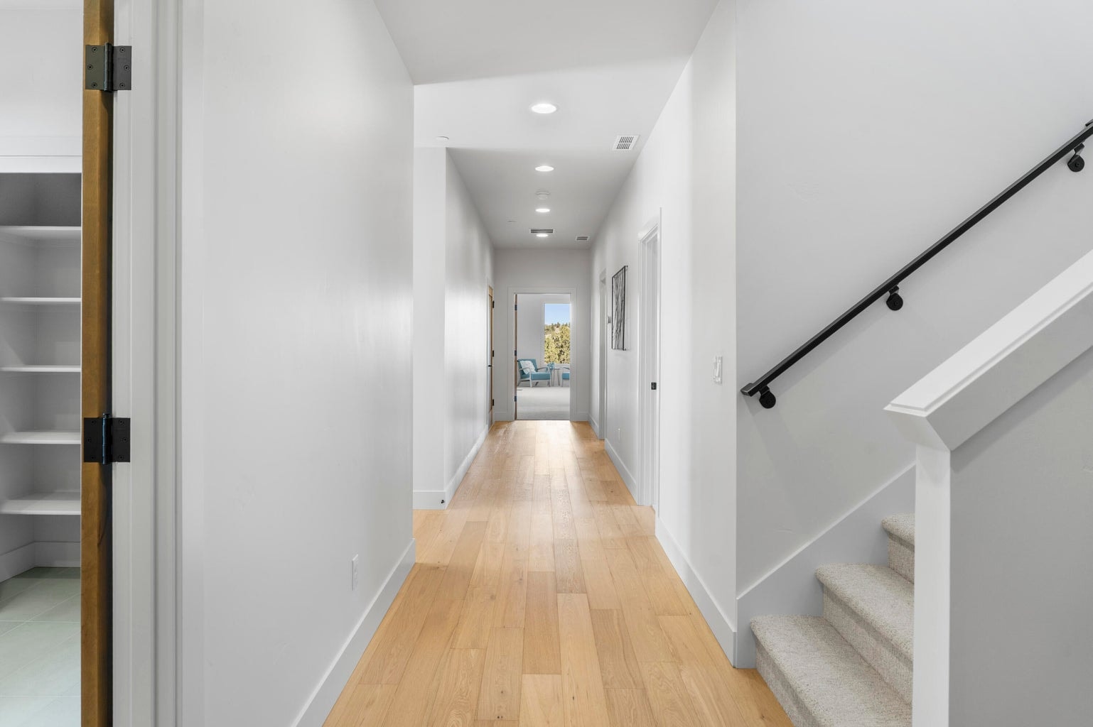 Hallway connects living, primary suite, office/bedroom, stairs, laundry, and garage