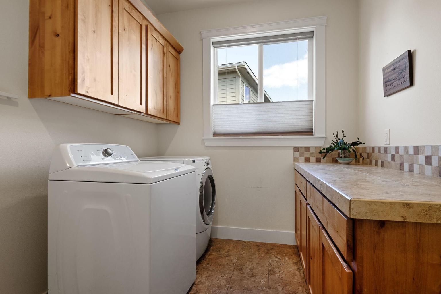 Nicely appointed utility room with storage off the kitchen and garage.