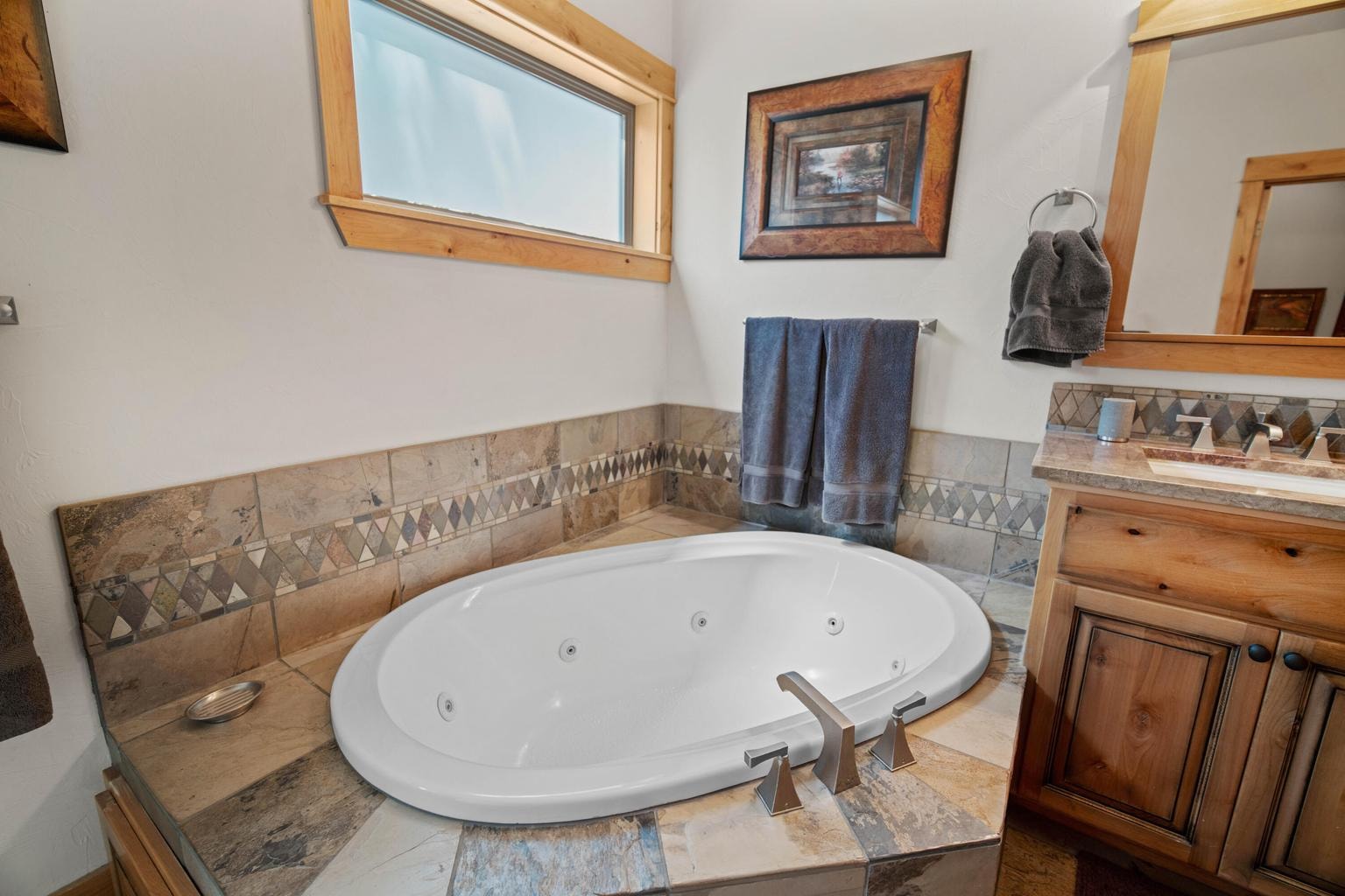 Tile-surround soaking tub creates a relaxing retreat within the primary bath suite.