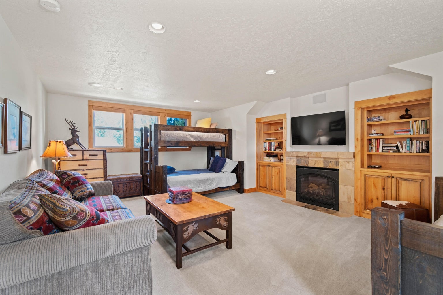 Spacious bonus room above the garage with fireplace, built-ins, bunks, lounge space, and room for guests.
