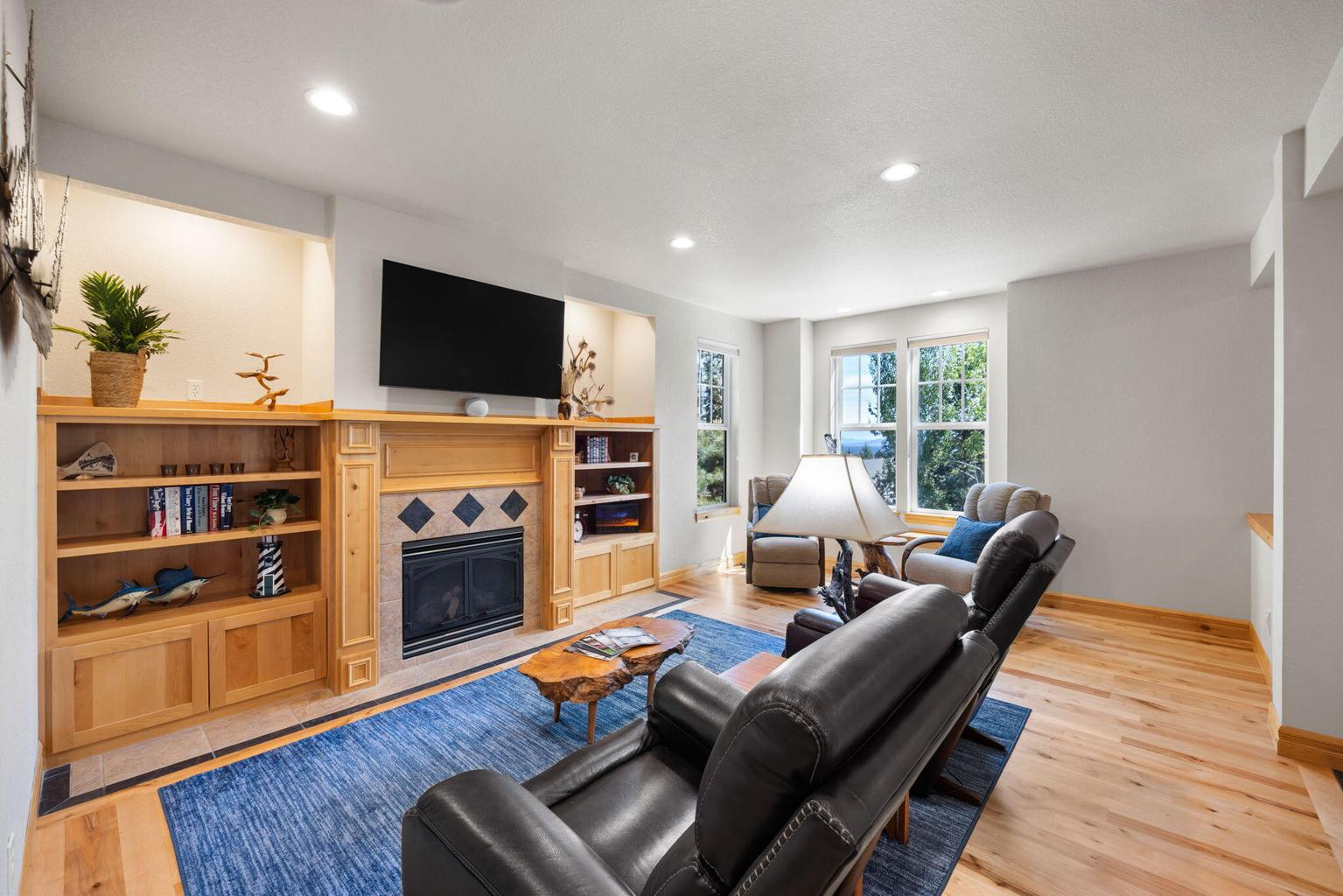 Living room has TV bracket that lowers screen over mantle
