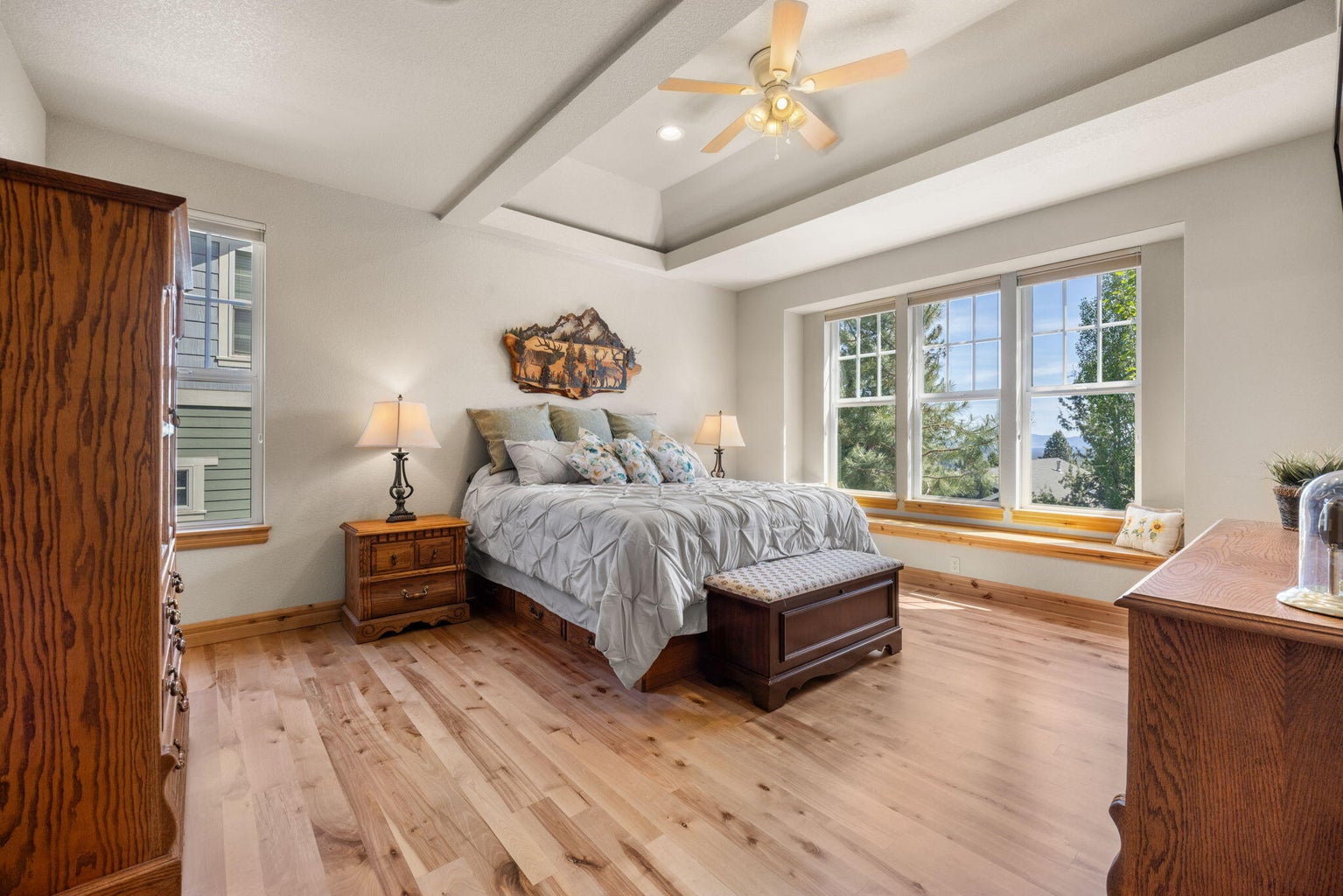 Spacious primary bedroom has coffered ceiling, smart lights, and front window seat