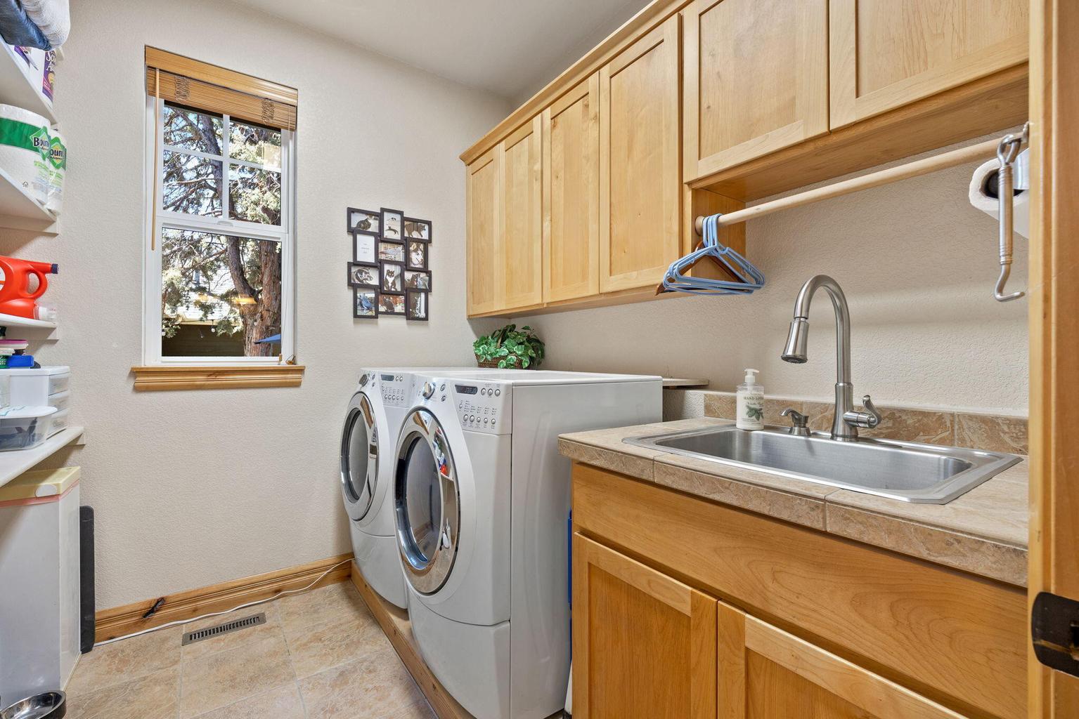Laundry room with large sink and a wall of shelving for abundant storage