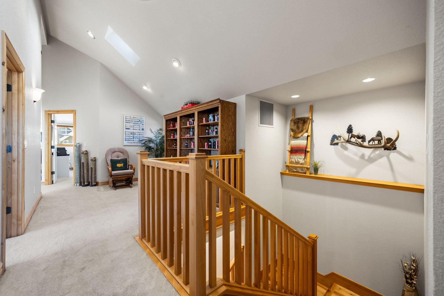 Large loft/gathering space at top of stairs has 2 skylights with solar shades