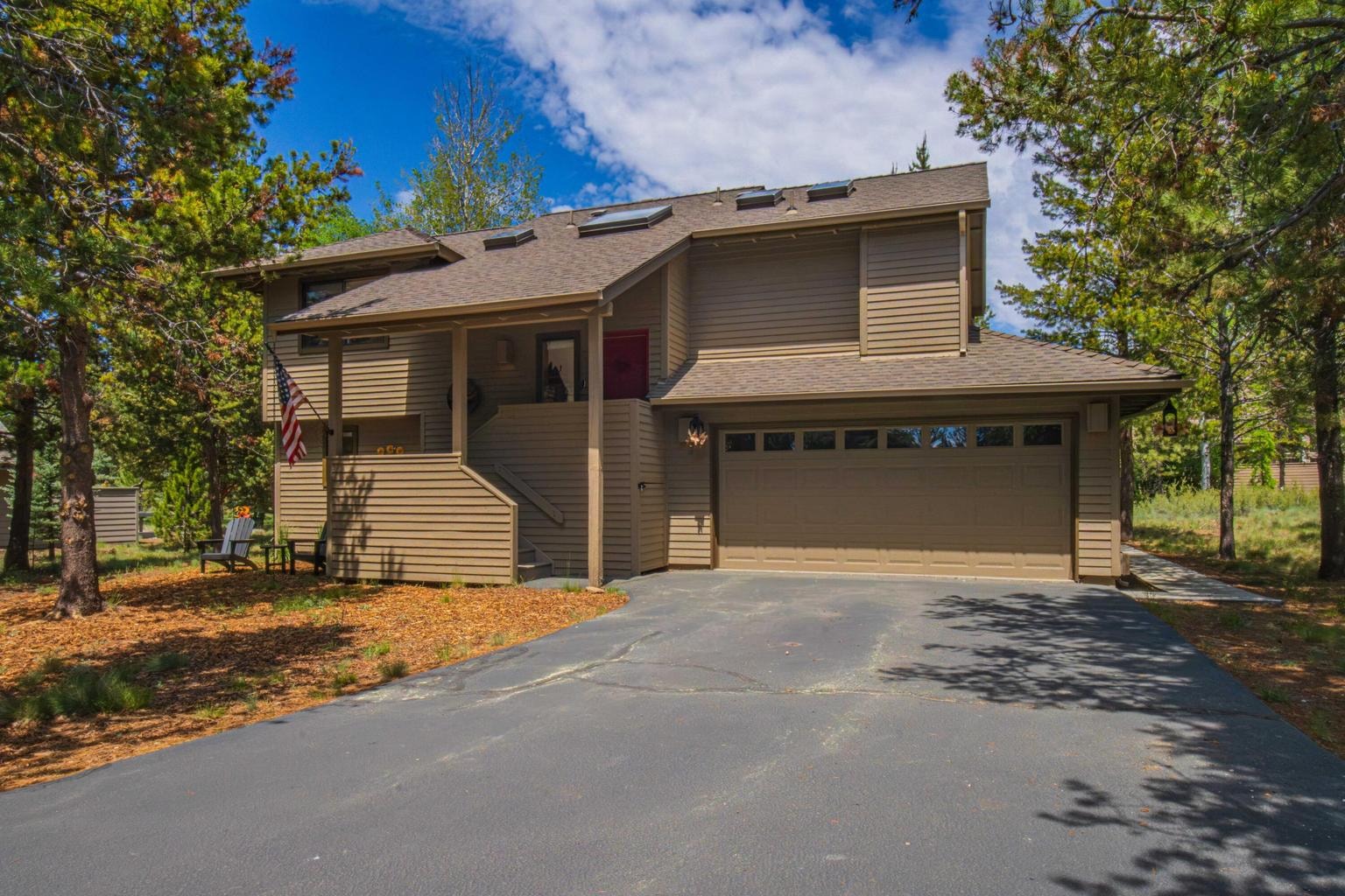 Attached two-car garage and covered front entry with natural pine setting.