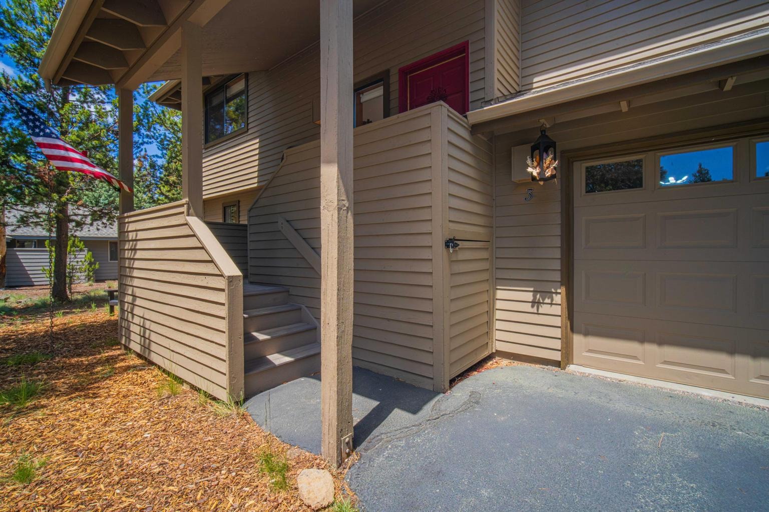 Covered entry approach with stairs, garage access, and protected arrival area.