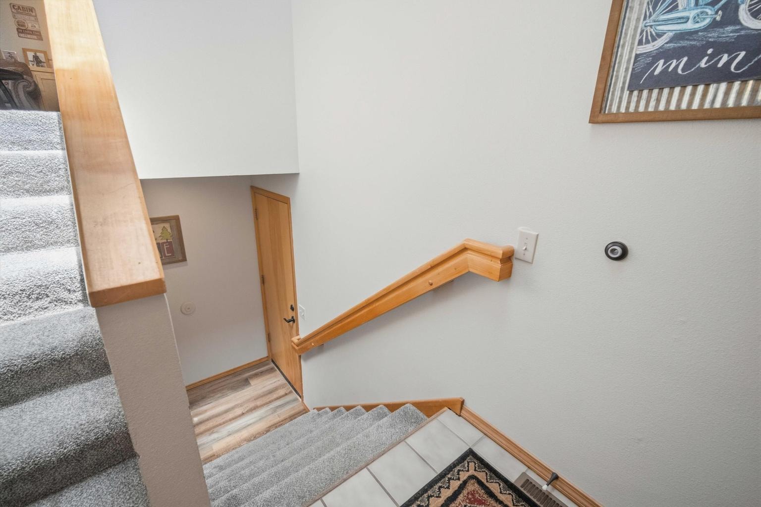 Split-level stair landing connecting the upper living spaces to the lower bedrooms and laundry.