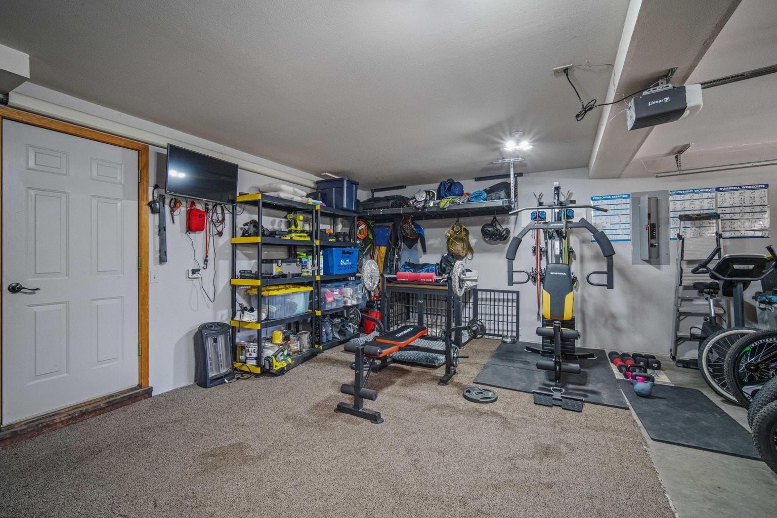Attached garage configured with fitness space, storage, and recreation gear organization.