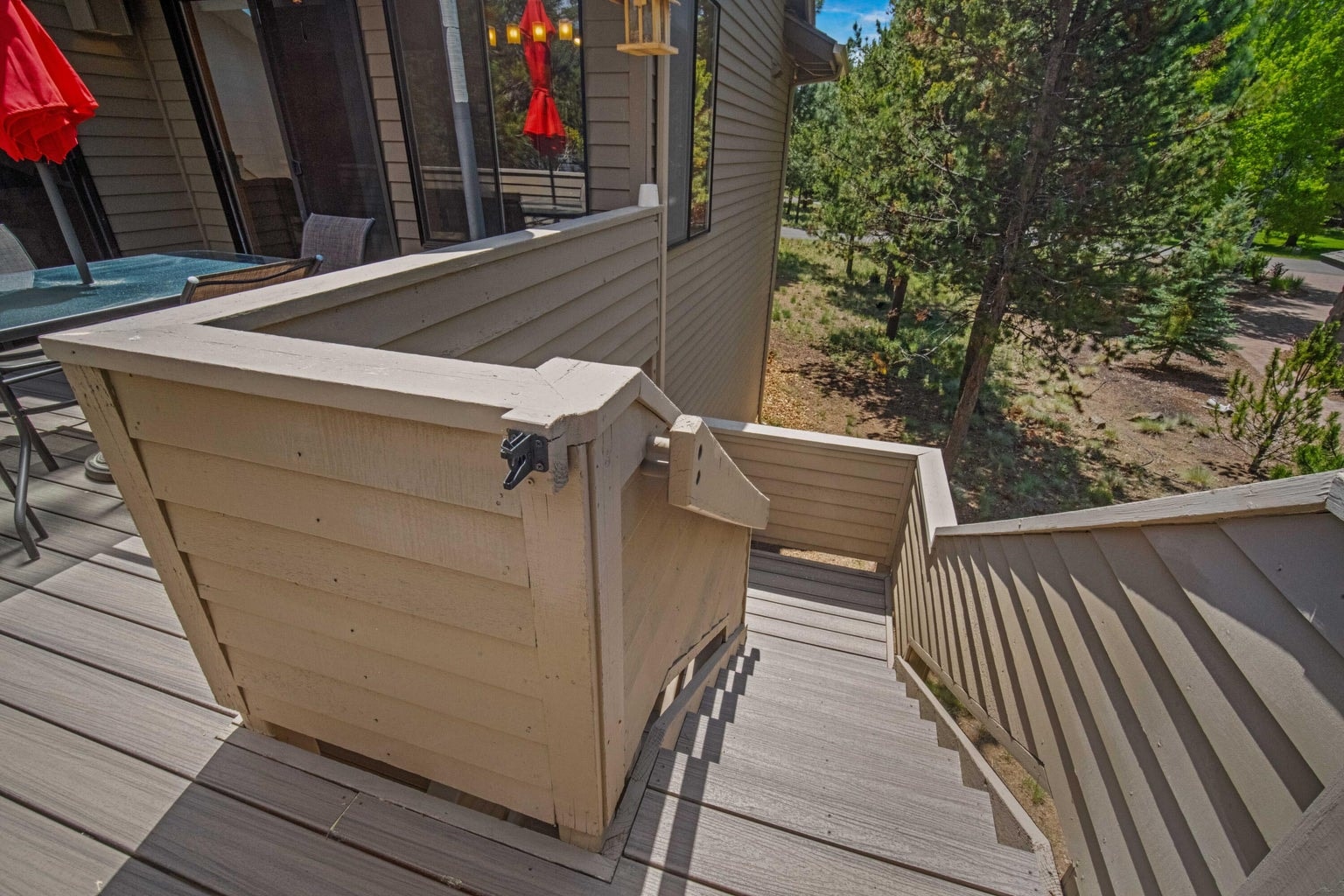 Updated deck stairs connect the upper outdoor living area to the lower covered patio.