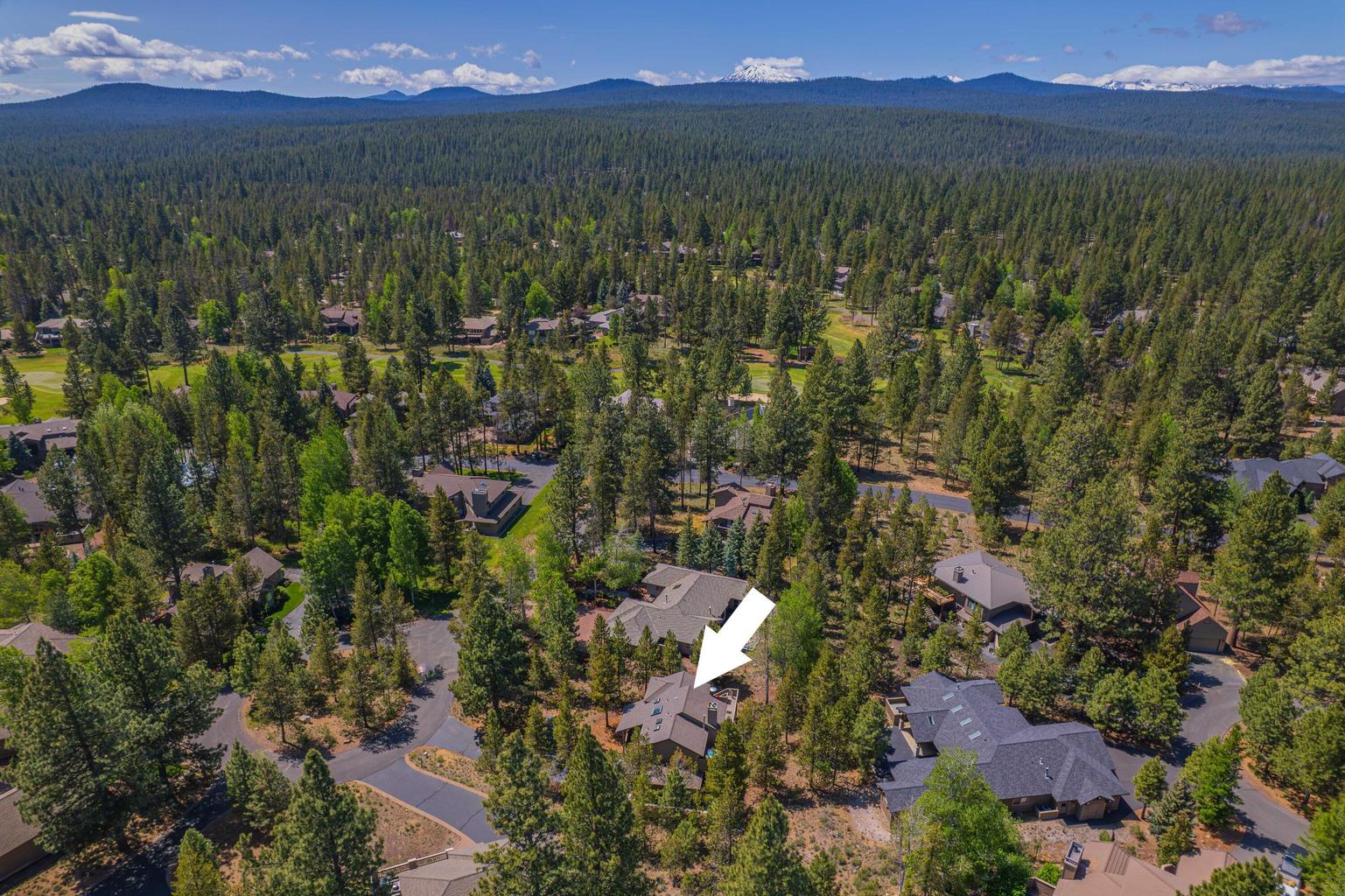 Aerial perspective over Sunriver, showing the forested setting and nearby golf course landscape.