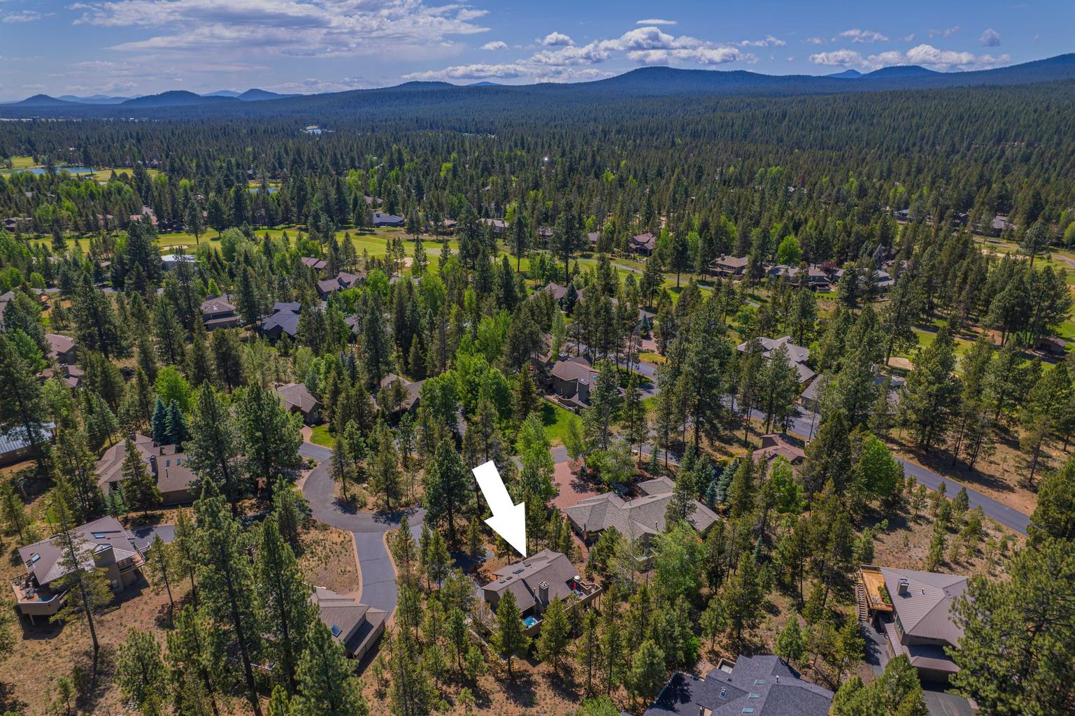 Elevated view of the Sunriver resort community with golf, trees, and mountain backdrop.