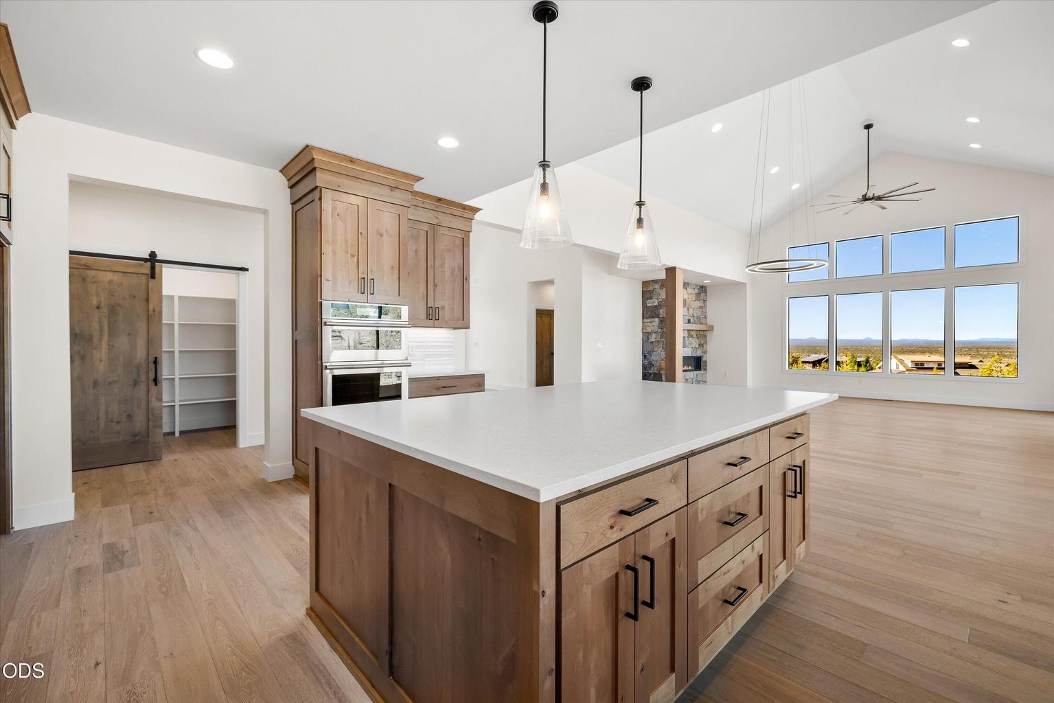 Oversized island with storage and seating areas, a second oven, and easy flow to massive pantry