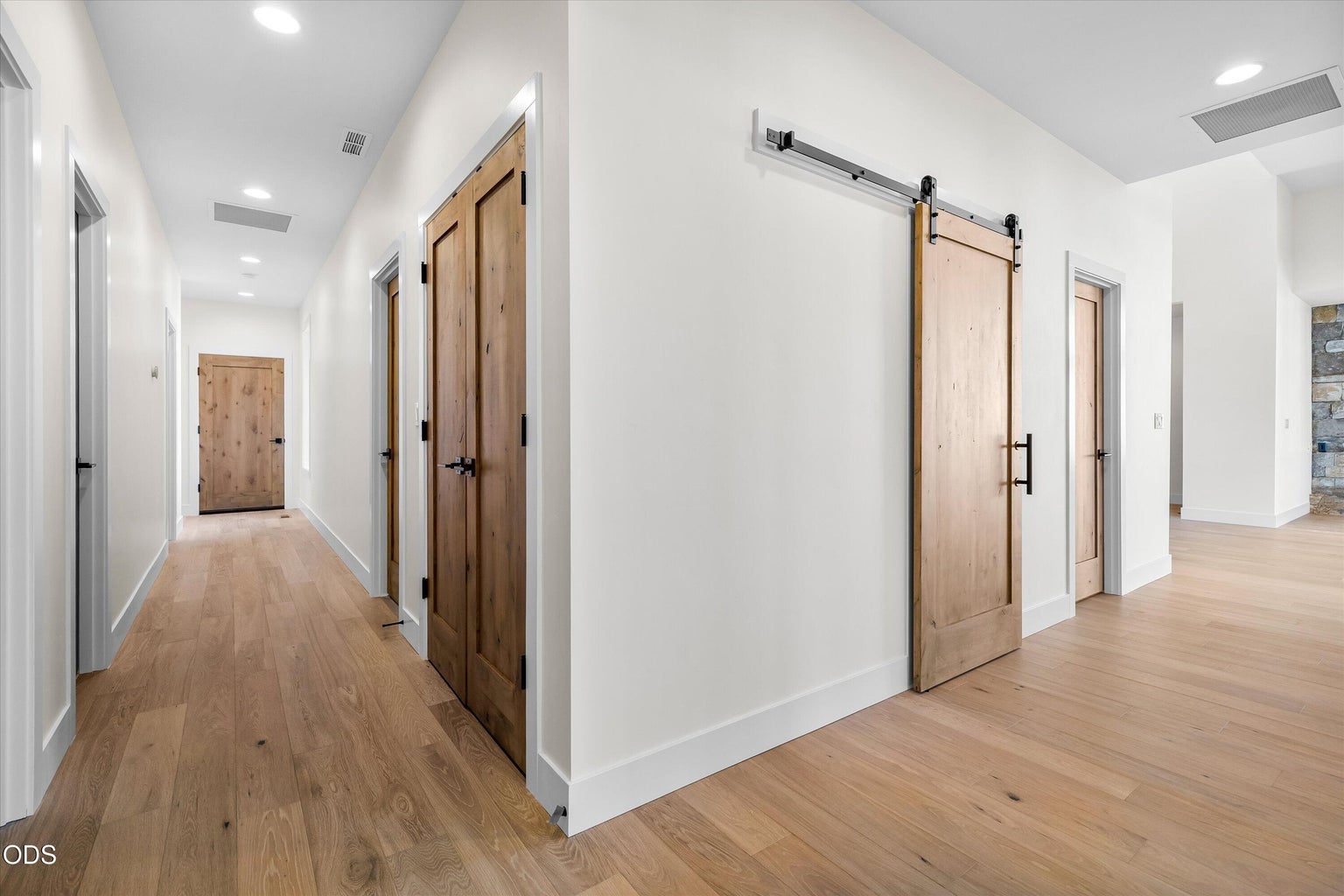 Hallway from primary back towards great room and 2nd primary on right, or straight to bedrooms 3 and 4, bonus room, laundry, and garage