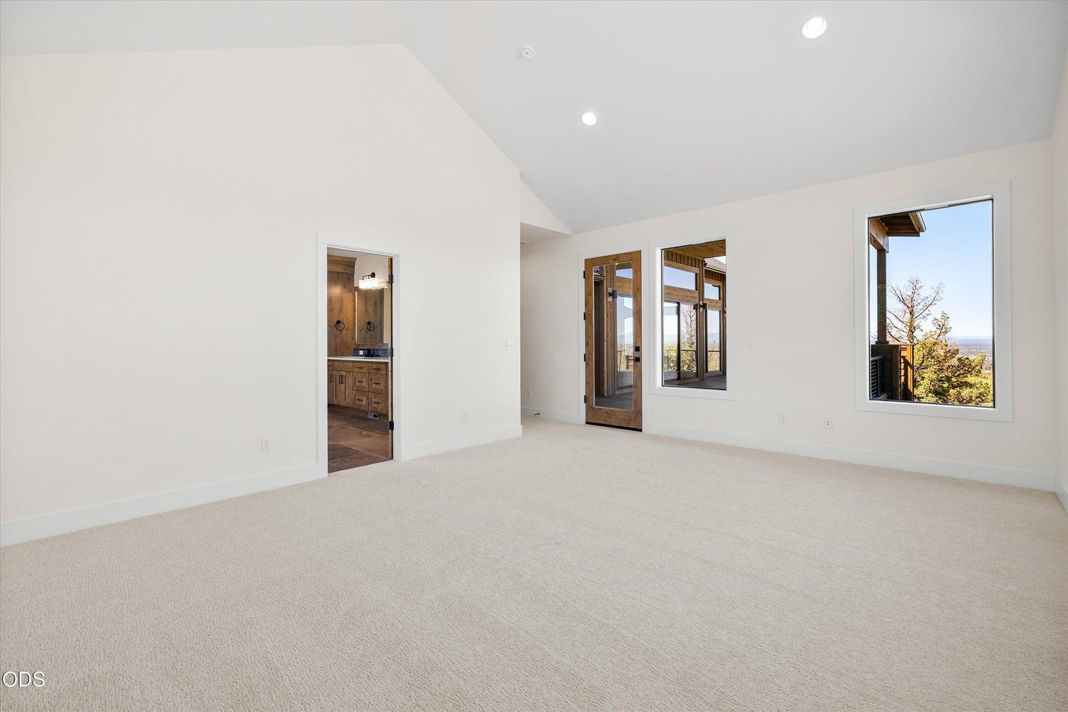 Primary bedroom features high ceilings, private deck access, and lots of natural light