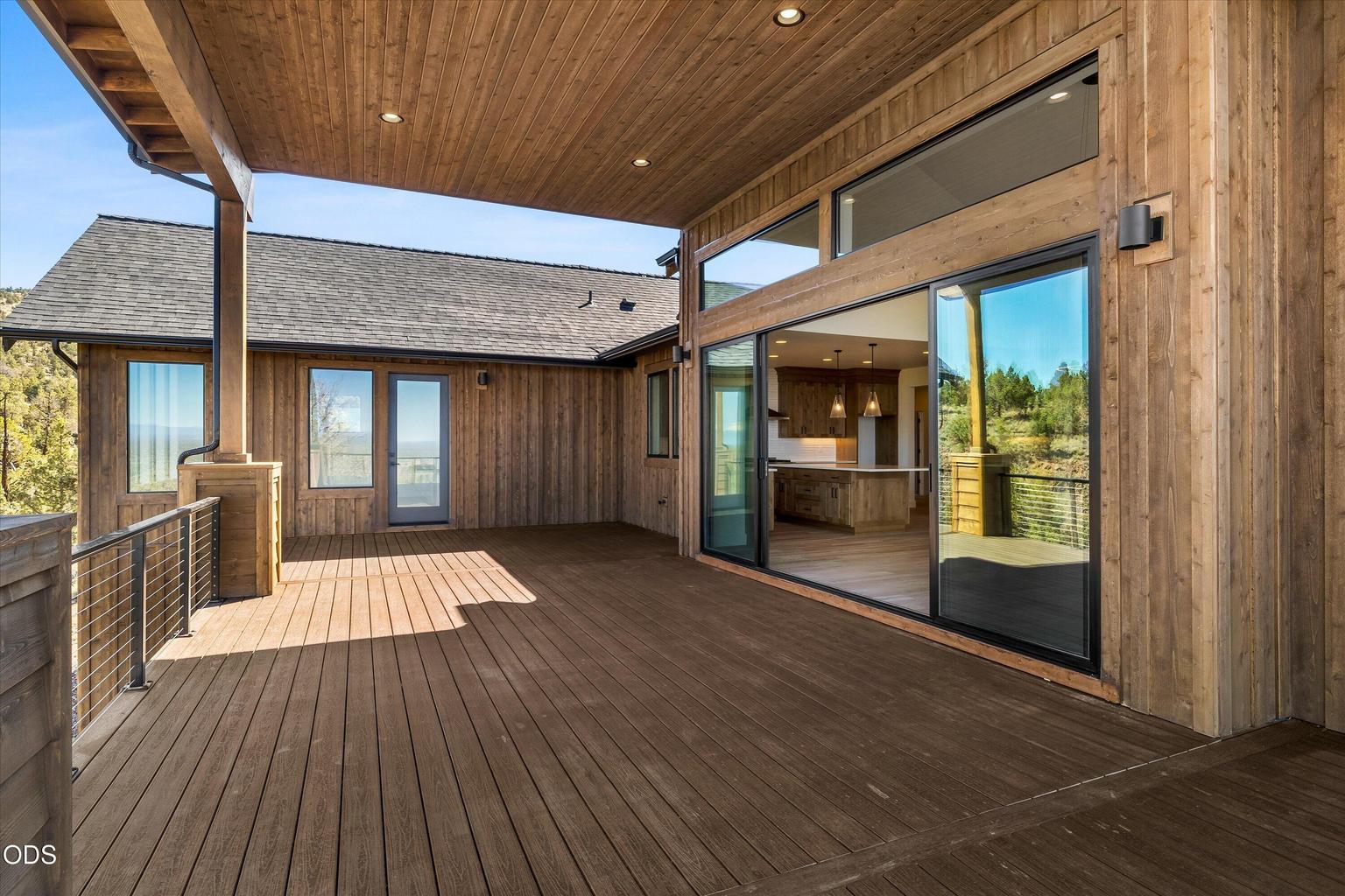Covered deck with ample space for outdoor dining, cooking, lounging, and hobbies