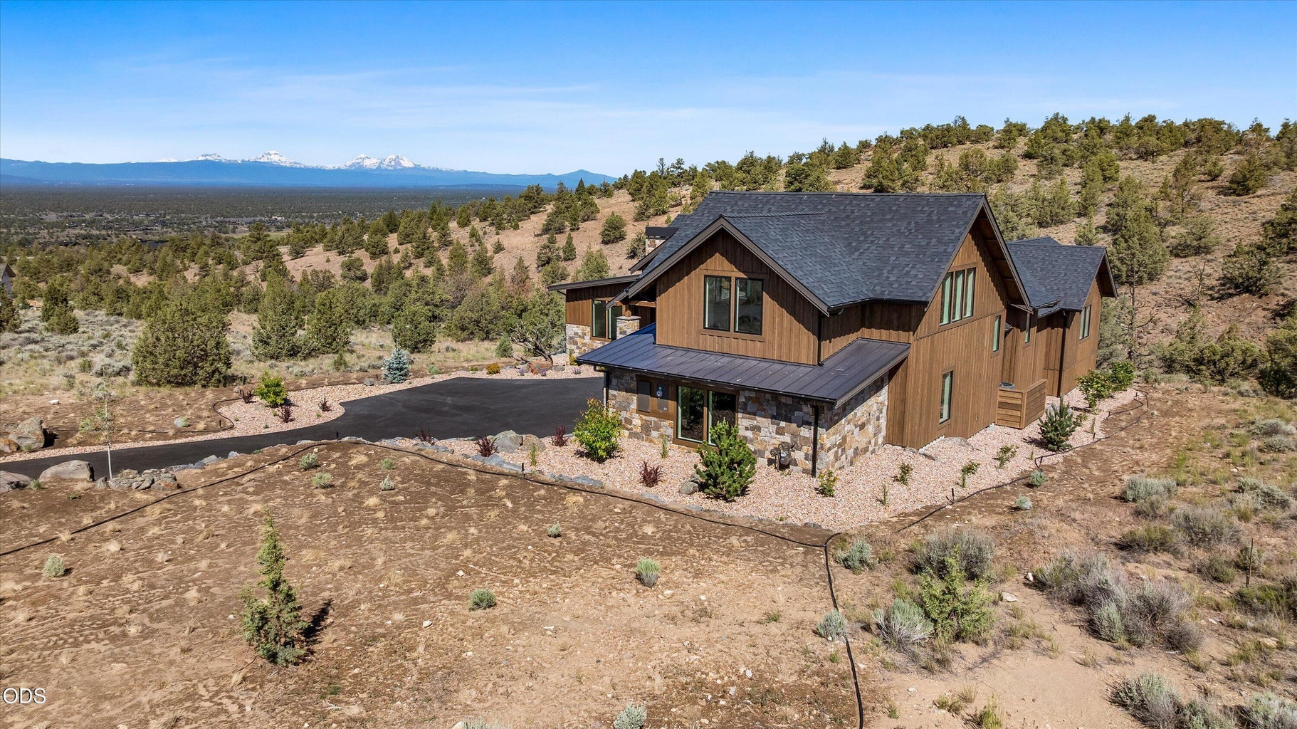 Aerial to Northwest showcases common space behind the home and natural landscape views for miles